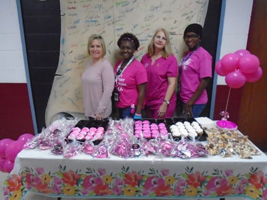 Team members smile during Breast Cancer Awareness Month